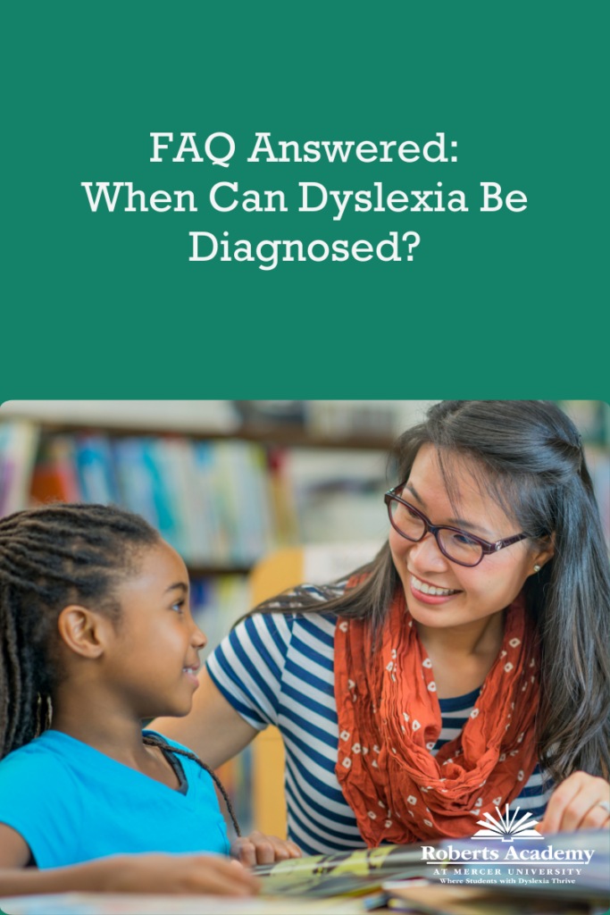 Text: FAQ Answered: When Can Dyslexia Be Diagnosed

Photo: A female teacher encourages a student while she reads. 