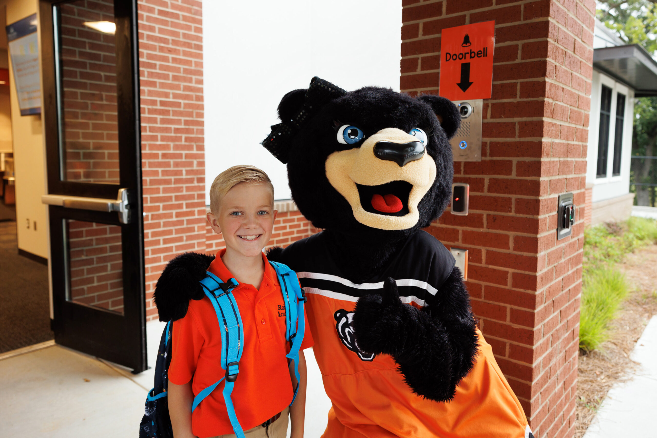 Tot, the Mercer University Mascot, poses with a Roberts Academy student