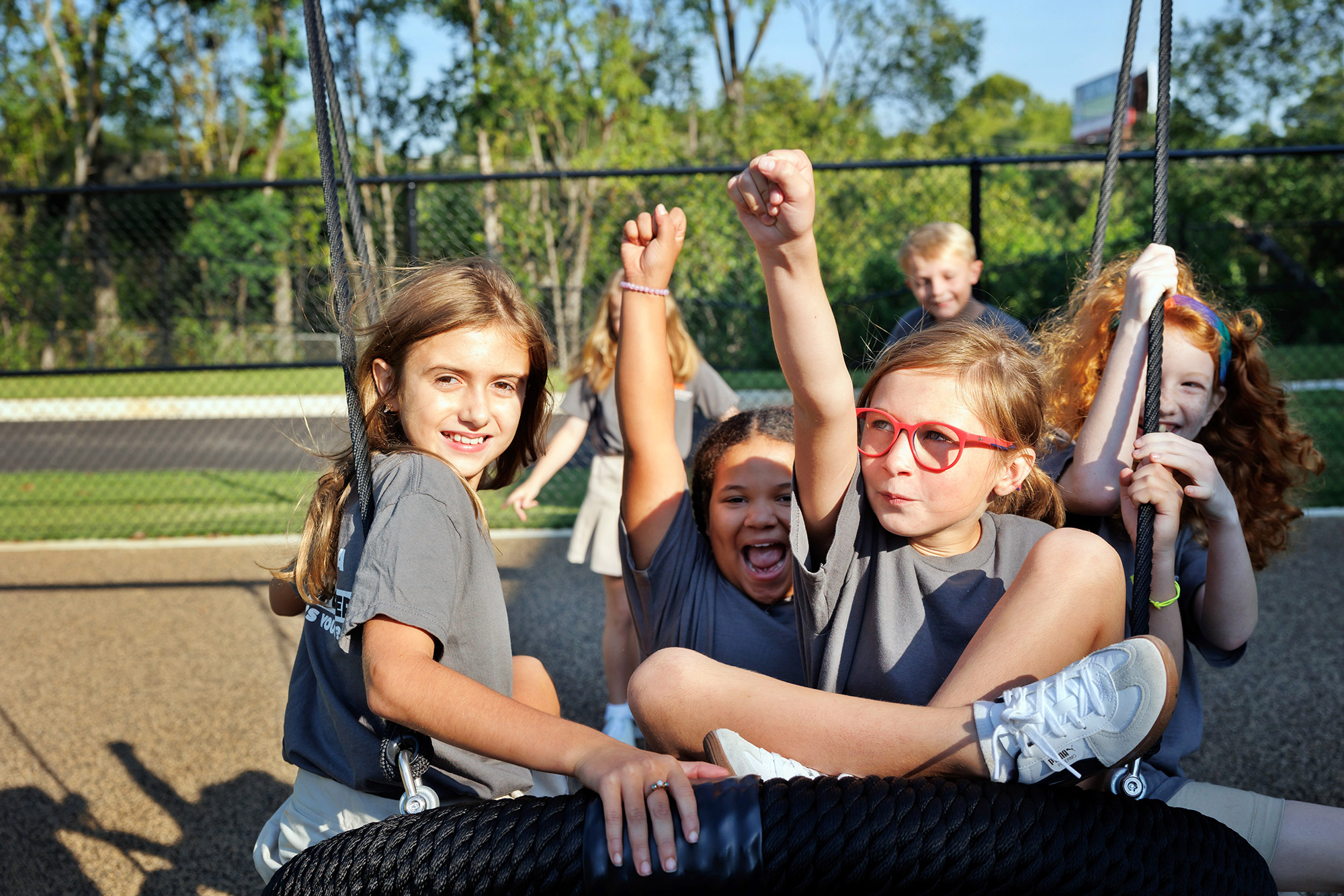 A group of children swinging in a swing on a playground