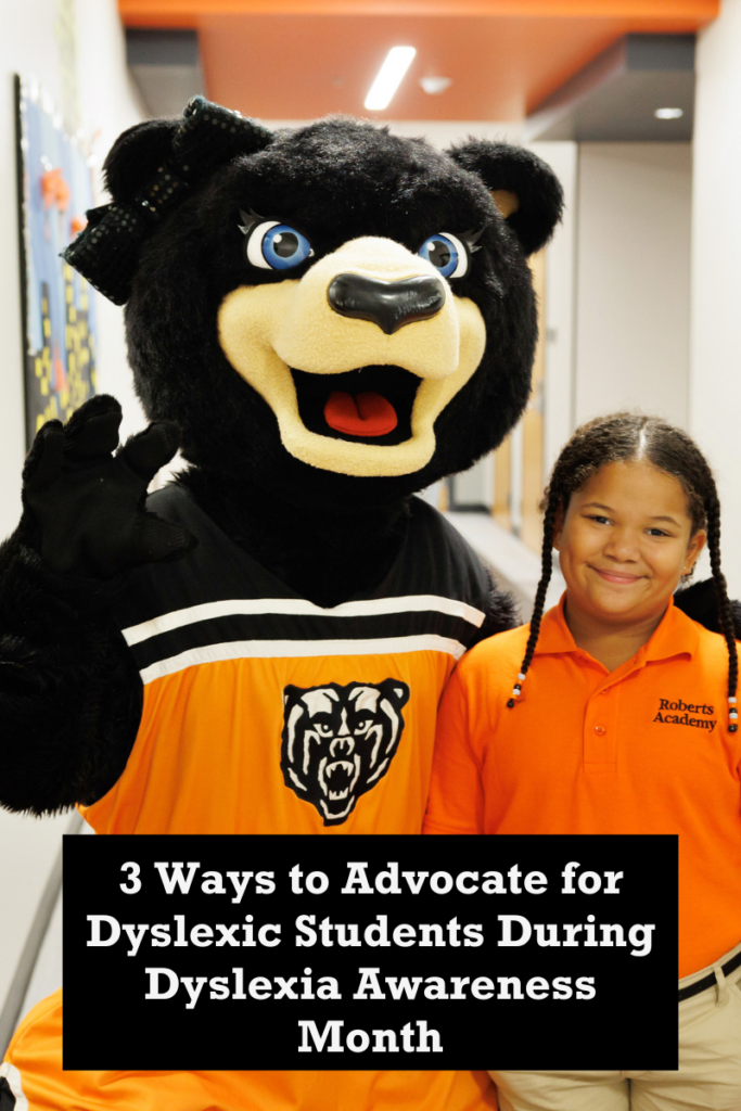 A student poses in the Roberts Academy hallway with Tot, the Mercer University Mascot. Text on photo reads: 3 Ways to Advocate for Dyslexic Students During Dyslexia Awareness Month