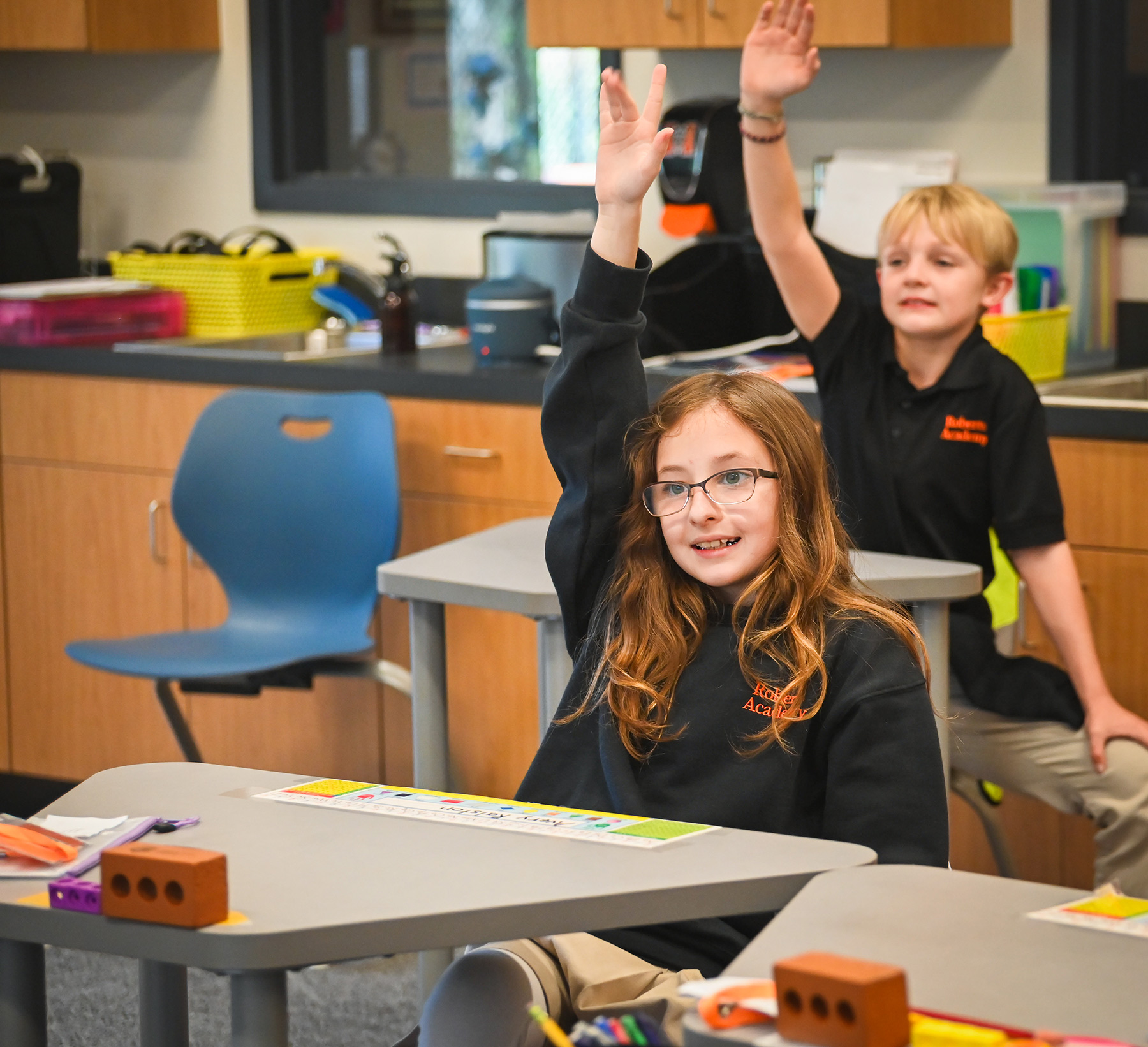 Children raising their hand in a classroom