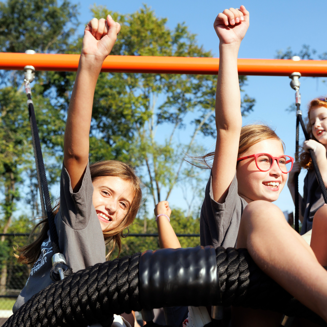 Roberts Academy at Mercer University students play on a swing on the playground