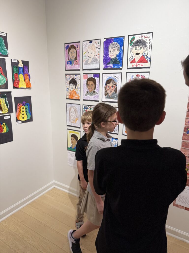 Student admires the self-portraits displayed during Roberts Academy at Mercer University's first student art show.