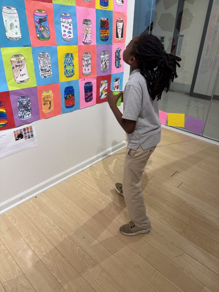 Roberts Academy 4th grader admires artwork the the students created throughout the school year at the first student art show