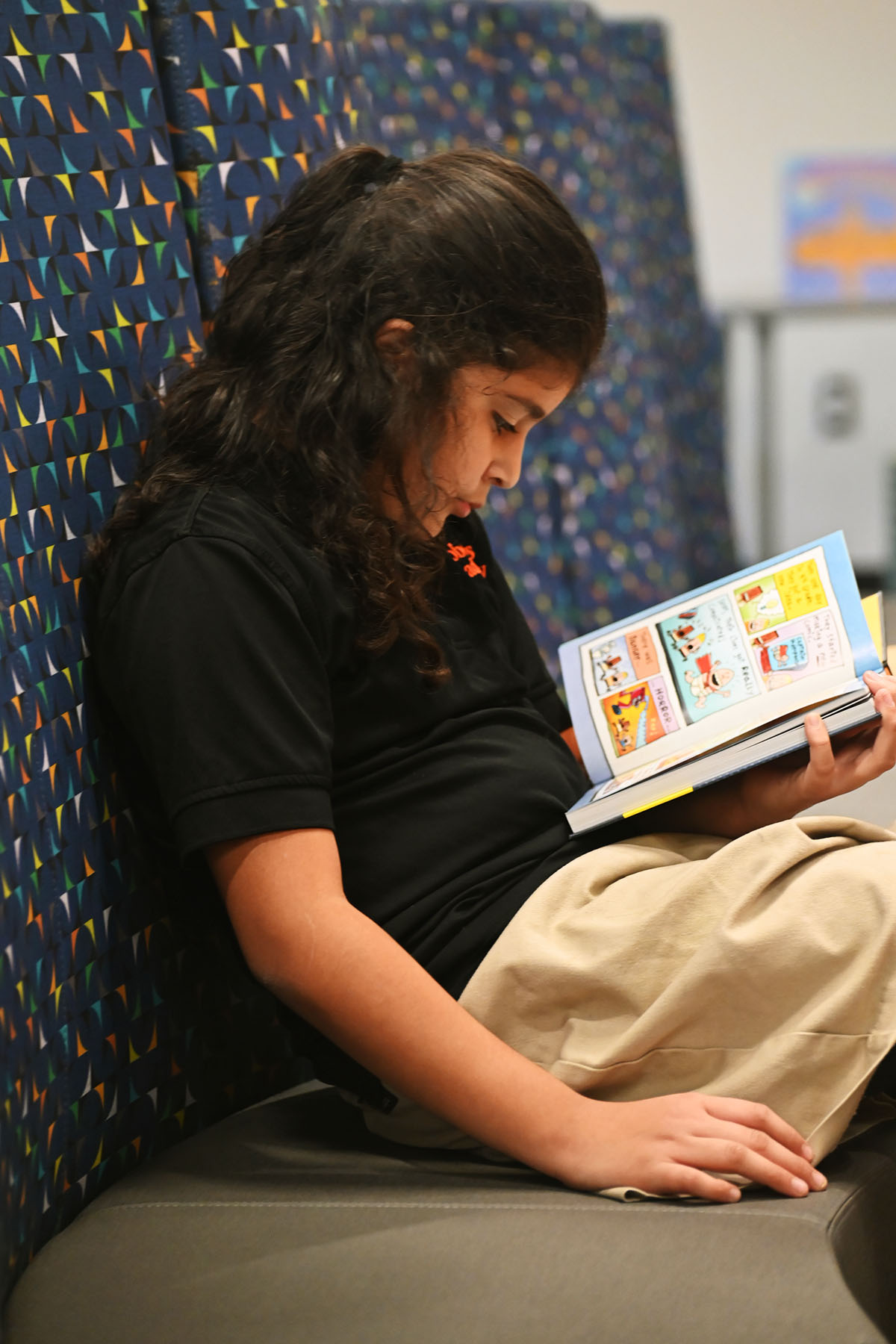 A young student reads in the Roberts Academy library.
