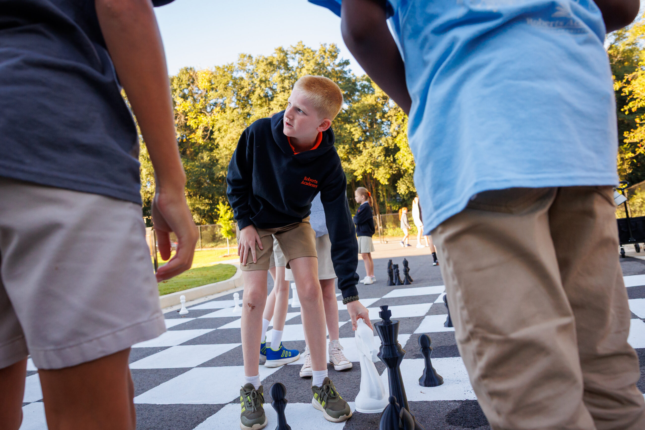 A student plays chess on a life-size chess board on the Roberts Academy at Mercer University playground in Macon, Georgia. 