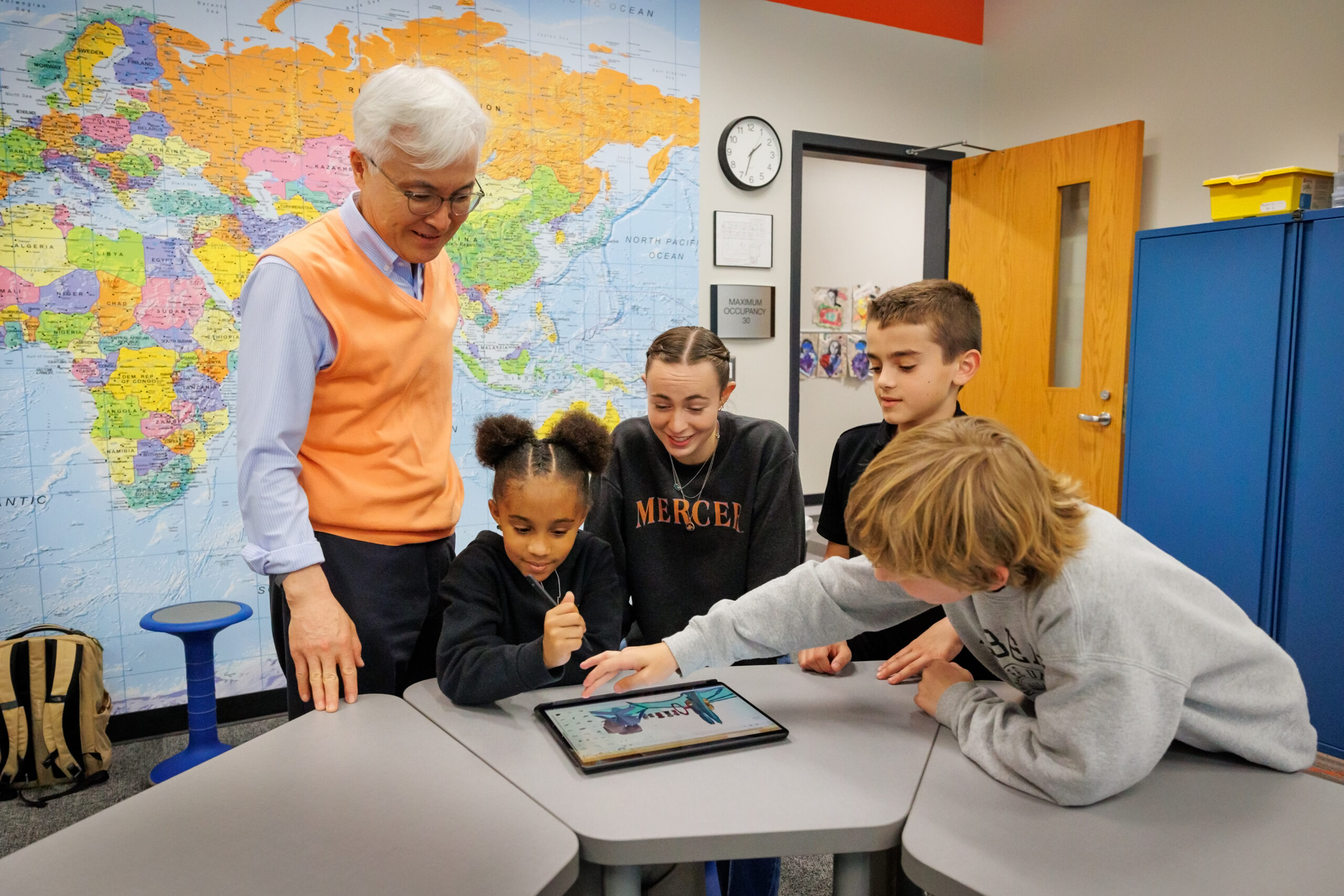 Roberts Academy students work with a professor and student in Mercer's School of Engineering to complete a STEM project using an iPad